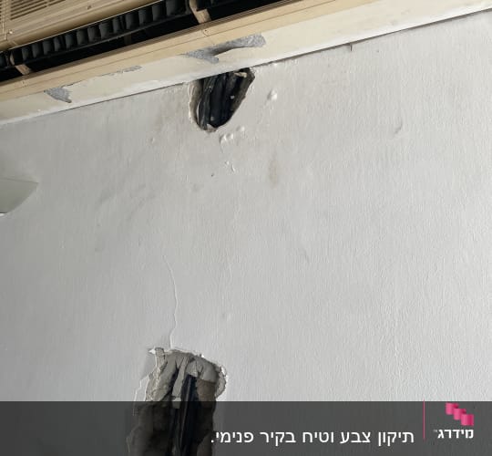 חורים בקיר עם צינורות חשופים מתחת למזגן